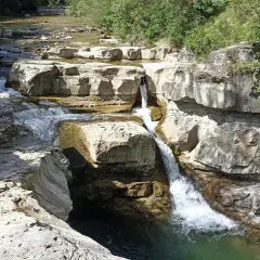 Cascate naturali scavate nella roccia vicino al monte Falterona. L'acqua cristallina scorre tra le rocce calcaree, creando un paesaggio suggestivo.