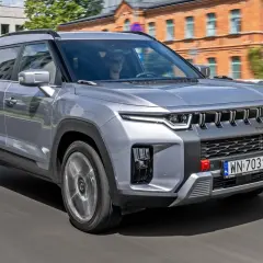 Srebrny SsangYong Torres jedzie ulicą.
