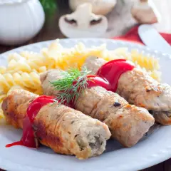 Roladki schabowe z pieczarkami, polane sosem, podane z makaronem fusilli i koperkiem.