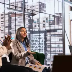 Two women in a meeting discuss business strategy, perhaps inspired by their organizational management degree.