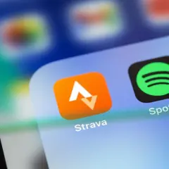 Ikona aplikacji Strava, idealna do śledzenia tras rowerowych, obok Spotify na ekranie smartfona.
