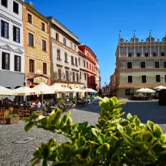 Słoneczny dzień na lublin stare miasto. Kolorowe kamienice, kawiarniane ogródki i brukowany plac tworzą urokliwą atmosferę.
