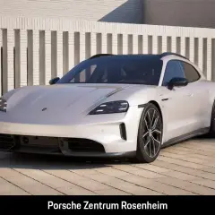 Biały Porsche Taycan Cross Turismo na tle nowoczesnej architektury. Sprawdź, jaka jest porsche taycan cena.