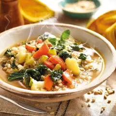 Un humeante tazón de sopa de cebada con kale, zanahorias y patatas. ¡Perfecto para tus recetas con kale!