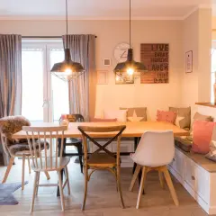 Gemütliches Esszimmer gestalten: Holztisch, Bank mit Kissen, verschiedene Stühle und Wanddeko schaffen einladendes Ambiente.