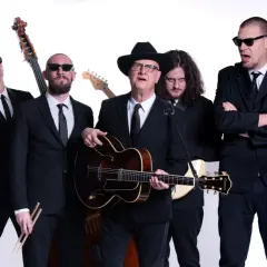 Diego Fornaciari e la sua band, tutti in abito scuro, pronti per un concerto.