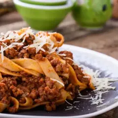 Pappardelle z bogatym sosem mięsnym, posypane parmezanem. Idealne pytanie: jakie mięso do spaghetti? Odpowiedź: mielone, duszone w sosie pomidorowym!
