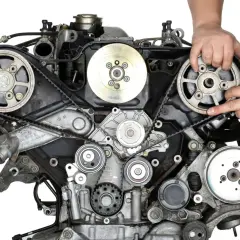 Mechanik sprawdza stan paska rozrządu w silniku samochodowym.