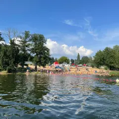 Słoneczny dzień nad jeziorem, pełnym ludzi kąpiących się i opalających. To jedne z fajnych miejsc nad wodą mazowieckie.
