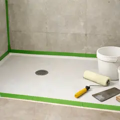 Préparation d'une douche : un receveur en résine, des seaux, un rouleau et une spatule. L'inconvénient ? La préparation minutieuse.