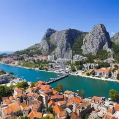 Widok na miasto Omis w Chorwacji z rzeką Cetina i górami w tle.