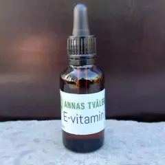En brun glasflaska med pipett innehåller Annas Tvåler E-vitamin för huden.
