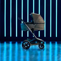 Elegancki wózek dziecięcy Maxi Cosi Fame na tle neonowych, niebieskich świateł.