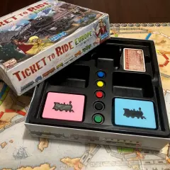 Das Spiel "Ticket to Ride: Europa" mit seinen vielen Zug um Zug Spiel Varianten. Die Spielschachtel und das Spielbrett sind zu sehen.