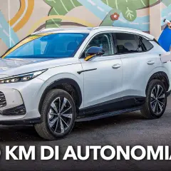 Un uomo con cavo di ricarica accanto a un MG HS Hybrid+ bianco, pronto per un viaggio di 1.100 km.