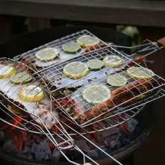 Grilla abborre med citron och lime på en kolgrill. Doften sprider sig i sommarkvällen.
