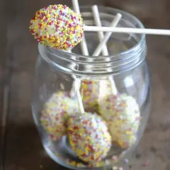 Bunte cake pops mit mascarpone, verziert mit Streuseln, stecken in einem Glas.