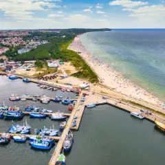 Jastrzębia Góra i okolice atrakcje: port rybacki, plaża pełna turystów, las i miasto.