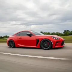 Deportivo rojo en carretera, con un escape que promete pops and bangs. Precio a consultar.