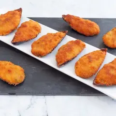 Ocho mejillones tigre dorados y crujientes, servidos en una bandeja blanca sobre una pizarra.