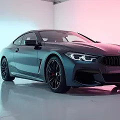 Eleganckie BMW serii 8, ciemnogranatowe coupe, w nowoczesnym studiu. To mistrzowska fotografia motoryzacyjna.