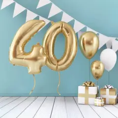 Złote balony z cyfrą 40, prezenty i girlanda tworzą idealną scenografię na wierszyk na 40 urodziny.