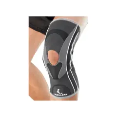 Szary stabilizator kolana Mueller HG80 z otworem na rzepkę, na nodze.