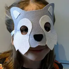 Dziecko w szarej masce wilka, idealnej do zabawy w leśniczego. Proste wykonanie, jak zrobić maskę wilka krok po kroku.