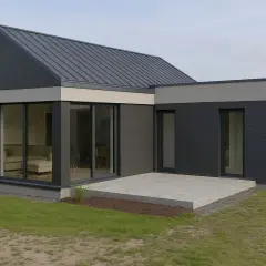 Nowoczesna dobudówka do starego domu, z dużymi przeszkleniami i grafitową elewacją. Projekty takich rozbudów to świetny sposób na unowocześnienie posiadłości.