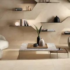 Eine moderne Wohnzimmerszene mit einer beigen Wand, einem geschwungenen Sofa, einem Sessel und einem Couchtisch.