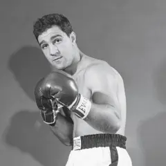 Boxer Rocky Marciano poses with his powerful Rocky Marciano hands in boxing gloves, ready for action.