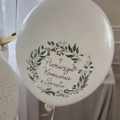 Białe balony z napisem "Pierwsza Komunia Święta" i motywem gołębicy oraz kielicha z hostią.