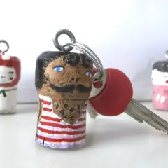 Portachiavi fatti a mano con tappi di sughero dipinti, perfetti per idee fai da te festa del papà. Un regalo unico e personalizzato.