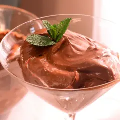 Deliciosa crema de cacao pralin, servida en copa de cóctel y decorada con menta fresca.