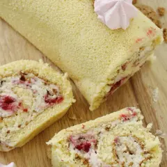 Puszysta rolada biszkoptowa z mascarpone i malinami, udekorowana różową bezą. Idealna na deser.