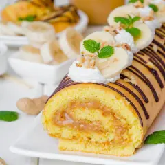 Najprostsza rolada biszkoptowa z kremem orzechowym i bananami, ozdobiona czekoladą i miętą.