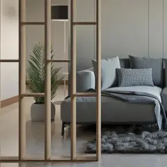 Ein modernes Wohnzimmer mit einer stilvollen Trennwand, die man auch selber bauen könnte. Ein bequemes Sofa und eine Pflanze schaffen Gemütlichkeit.