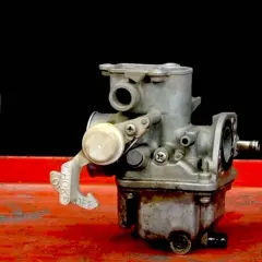 Carburador de moto con palanca de choke. Si la moto se apaga en ralentí, podría ser un problema aquí.