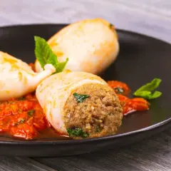 Calamari ripieni in friggitrice ad aria, serviti con salsa rossa e menta fresca. Un piatto gustoso e leggero.
