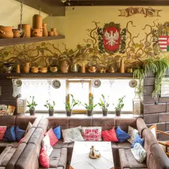 Wnętrze tokaj restauracja węgierska menu. Wygodne kanapy, ozdobne malowidła na ścianie i ceramiczne naczynia tworzą przytulną atmosferę.