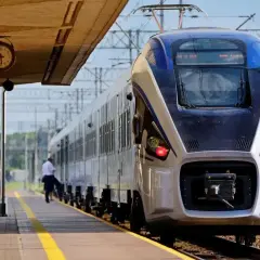 Pociąg Intercity na peronie. Zastanawiasz się, czy można jechać wcześniejszym pociągiem Intercity? Zegar na stacji pokazuje czas.