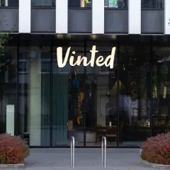 Logo Vinted na budynku. Chcesz wiedzieć, jak zmienić cenę na Vinted? Sprawdź instrukcję!