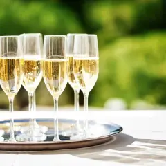 Six flûtes de champagne pétillant sur un plateau argenté, prêtes pour le dessert. Quel champagne pour le dessert ?