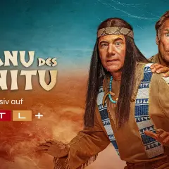 Das Kanu des Manitu" streamt exklusiv auf RTL+. Zwei Männer, einer im Indianer-Look, der andere im Western-Stil, blicken überrascht.