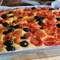 Focaccia con pomodorini e olive nere, un'esplosione di sapori che ricorda la semplicità di un pasto come quello di Rossella, pane e cioccolato.
