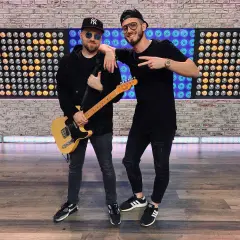 Dwóch muzyków, jeden z gitarą, gotowych do nagrania nowych łobuzy utwory.