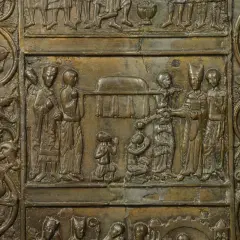 Fragment Drzwi Gnieźnieńskich: scena z postaciami w strojach historycznych i ornamentem roślinnym.