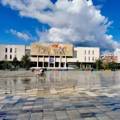 Plac Skanderbega, serce stolicy Albanii, z monumentalnym budynkiem i mozaiką.