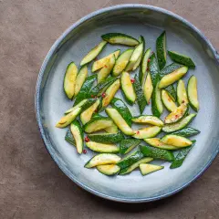 Gebratene Zucchinischeiben mit roten Pfefferflocken in einer Schüssel, eine einfache Idee für Zucchini Rezepte.
