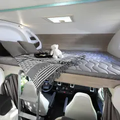 Lit douillet de camping-car, prêt pour un doux rêve de papillon.